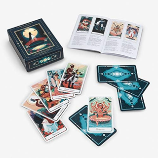 Tarot cards with artwork and an open book on a white background