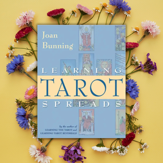 Book titled 'Learning Tarot Spreads' by Joan Bunning surrounded by flowers on a yellow background