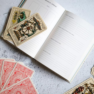 Tarot cards and a notebook on a textured surface
